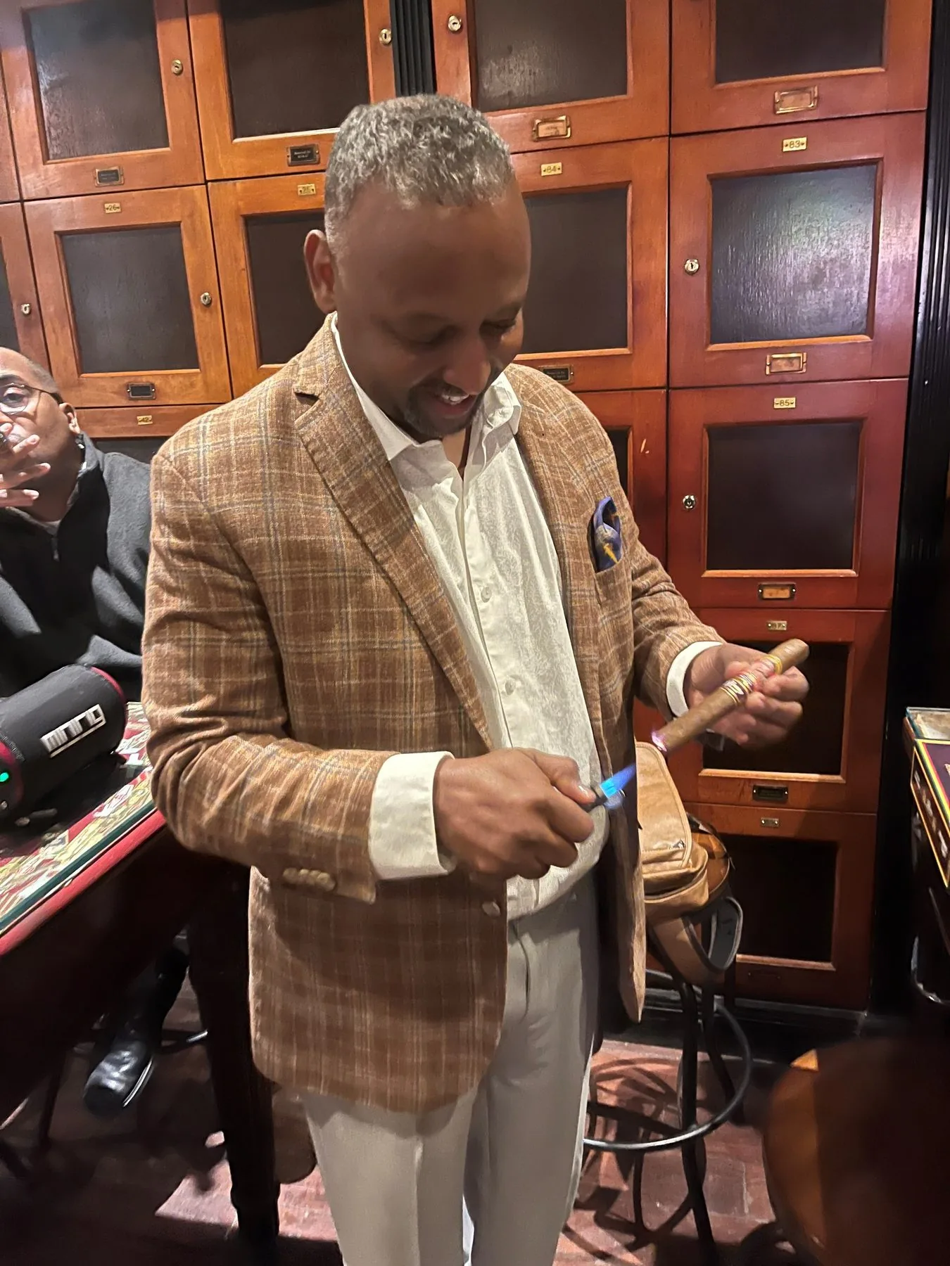 Benny, founder of Benny Cigars, lighting a cigar in the humidor